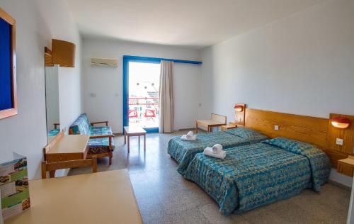 a hotel room with a bedroom with a bed and a desk at Green Bungalows Hotel Apartments in Ayia Napa