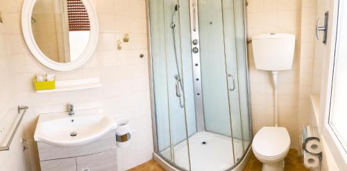 a bathroom with a shower and a toilet and a sink at Hotel Le Ali in Rimini