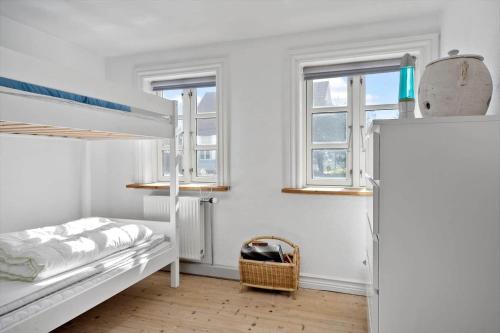 a bedroom with two bunk beds and two windows at 1073-Thisted-Orhagevej-30 in Klitmøller
