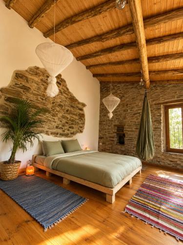 a bedroom with a bed and a brick wall at Quinta WOW in Benfeita