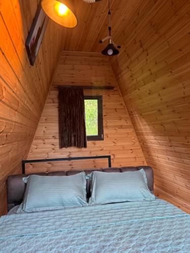 a bedroom with a bed in a wooden cabin at Barbare Cottage in Chakvi
