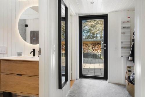 a bathroom with a sink and a door with a mirror at 1385-Bedsted-Thy-Nedergardsvej-5 in Istrup