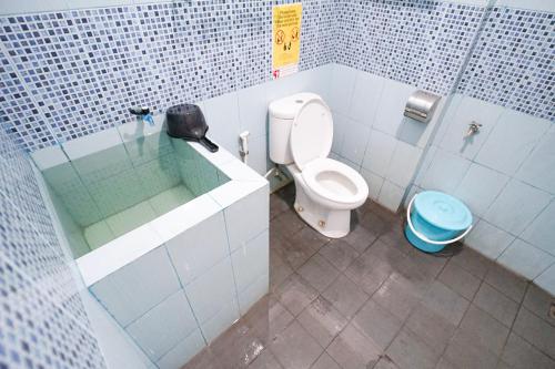 a bathroom with a toilet and a glass shower stall at Omah Alamanda in Sleman