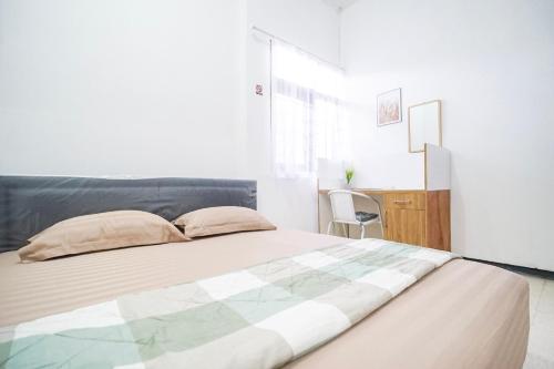 a bedroom with a large bed and a desk at Omah Alamanda in Sleman