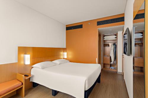 a bedroom with a large bed and a closet at Ibis Abu Dhabi Gate in Abu Dhabi