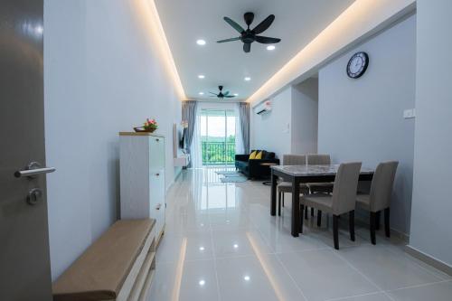 a dining room and living room with a table and chairs at Trival Property Homestay Sri Indah Sandakan in Sandakan