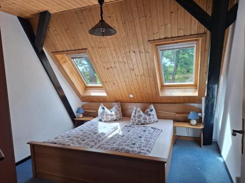 a bedroom with a bed and two windows at Hof Junkernberg in Bispingen
