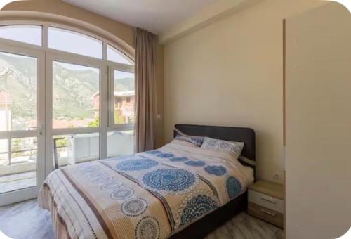 a bedroom with a bed and a large window at Art GuestHouse in Kotor