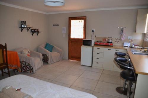 a kitchen and living room with a couch and a table at Maskam Guest Farm in Vanrhynsdorp