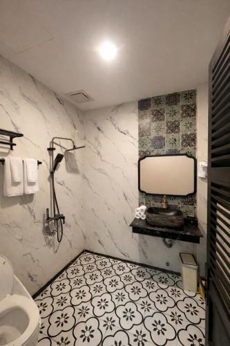 a bathroom with a toilet and a mirror on the wall at LV Homestay in Nha Trang