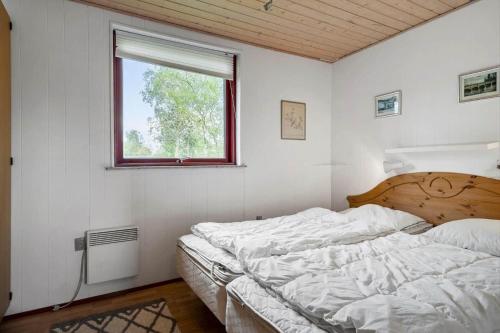 a white bedroom with a bed and a window at 1039-Stege-Rylevej-30 in Stege