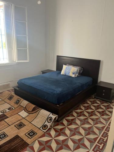 a bed sitting in a room with a rug at 3 bedroom Villa with garden in Ez Zahra