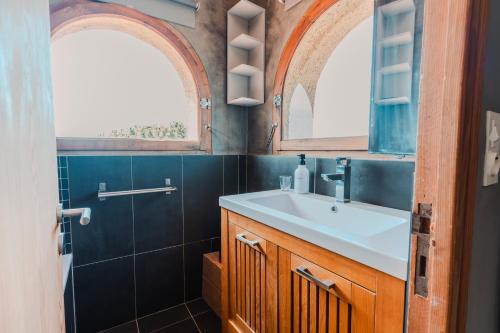 a bathroom with a sink and two windows at La Tour de La Palme in Lapalme