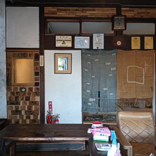 a room with a table and a couch and a window at Hakodate Guest House in Hakodate