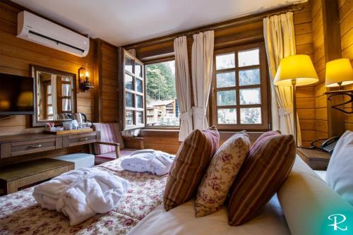 a bedroom with a bed with pillows and a desk at Royal Uzungol Hotel&Spa in Uzungöl
