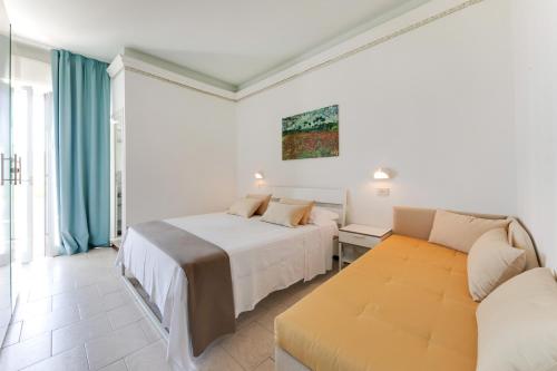 a bedroom with two beds and a couch at Hotel Simon in Gatteo a Mare
