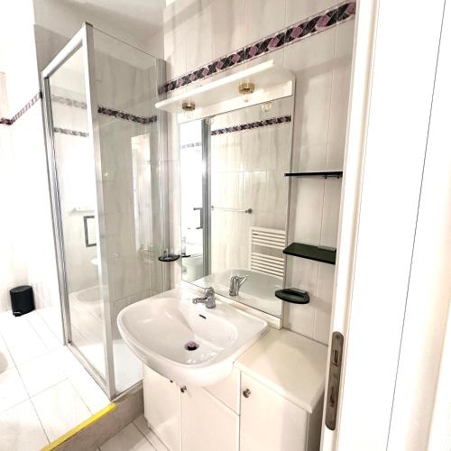 a white bathroom with a sink and a shower at Residenz In 1 in Bardolino