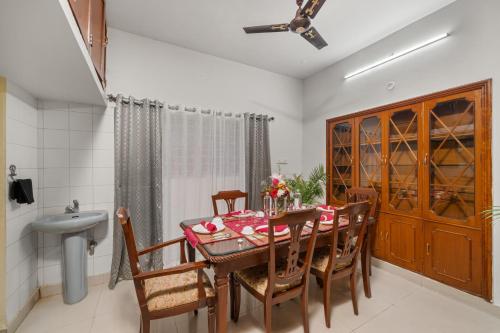 a dining room with a table and chairs and a sink at Vintage Haven Leafy Getaway Luxury Villa in Indiranagar by Spacez in Bangalore