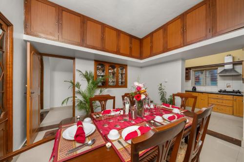 a dining room with a table and a kitchen at Vintage Haven Leafy Getaway Luxury Villa in Indiranagar by Spacez in Bangalore