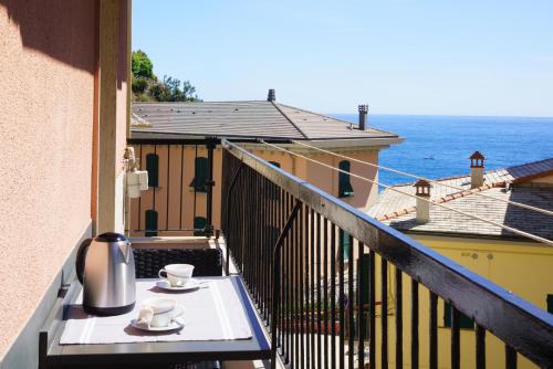 a table with two cups on a balcony with the ocean at Respiro di Mare in Riomaggiore