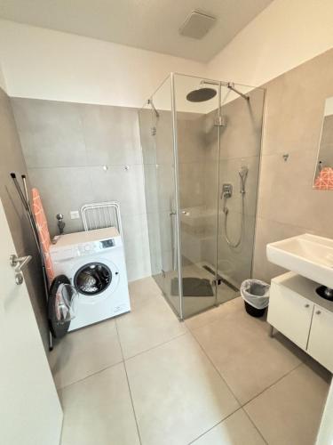 a washing machine in a bathroom with a shower at Krems am Campus in Krems an der Donau