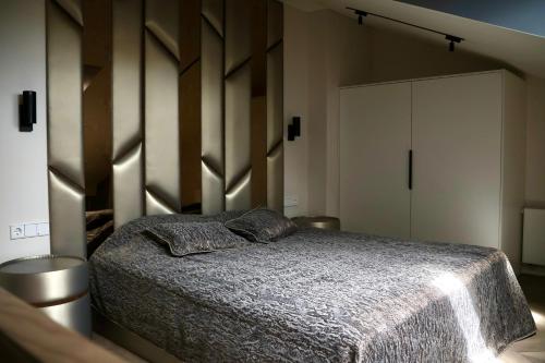 a bedroom with a bed with a wooden headboard at Bohemia Jacuzzi & Sauna Apartment in Klaipėda