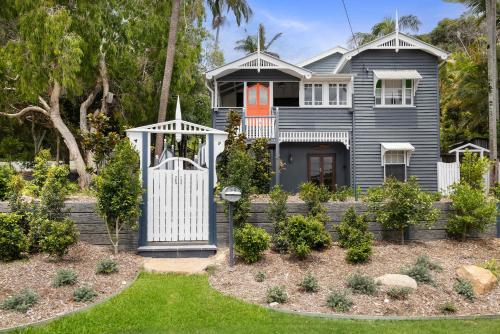 a house with a white gate in a yard at Pacific Terrace Beach House in Coolum Beach