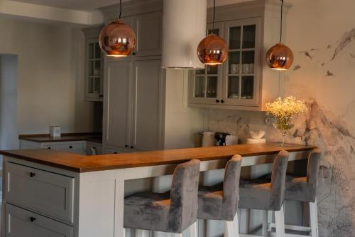 a kitchen with a large wooden counter with chairs around it at KAJKl 15 in Lidzbark Warmiński