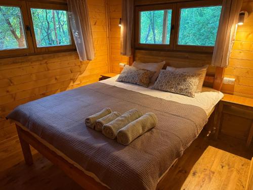 a bed in a log cabin with three pillows on it at Wilgano in Rvaši