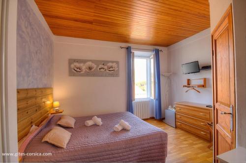 a bedroom with a bed with a wooden ceiling at U san larenzu in Aullène