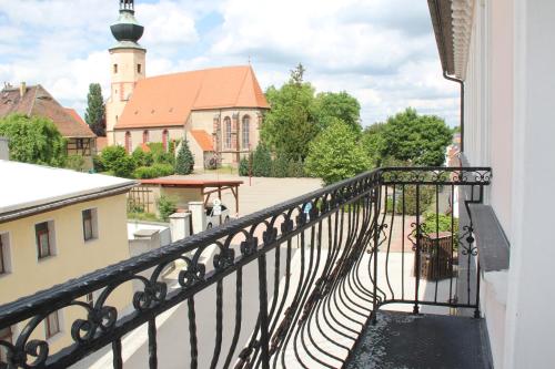 a balcony with a view of a building and a church at Hotel Schloßblick Trebsen in Trebsen