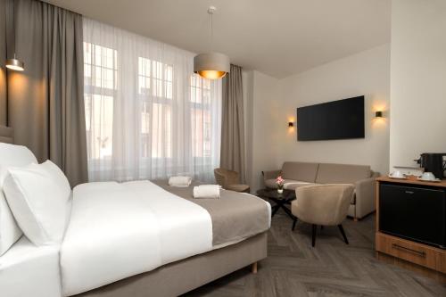 a hotel room with a bed and a living room at Evergreen Suites Budapest in Budapest