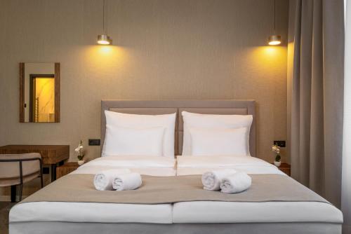a bedroom with a bed with towels on it at Evergreen Suites Budapest in Budapest