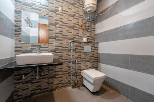 a bathroom with a white toilet and a sink at The Namami Tapovan in Rishīkesh