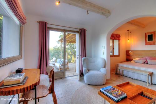 a bedroom with a bed and a desk and a table at Casa penisula in Porto-Vecchio