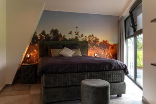 a bedroom with a large bed with a fire mural on the wall at De Hooiberg in Ritthem