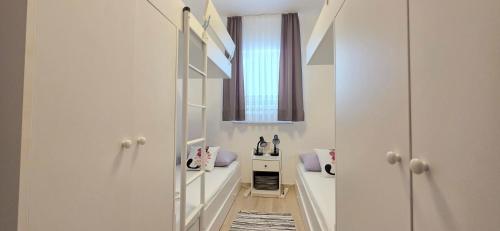 a room with white walls and a hallway with a window at Guest House Jasna in Novalja