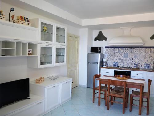 a kitchen with white cabinets and a table with chairs at Casa TerryB - il Monticello in Positano