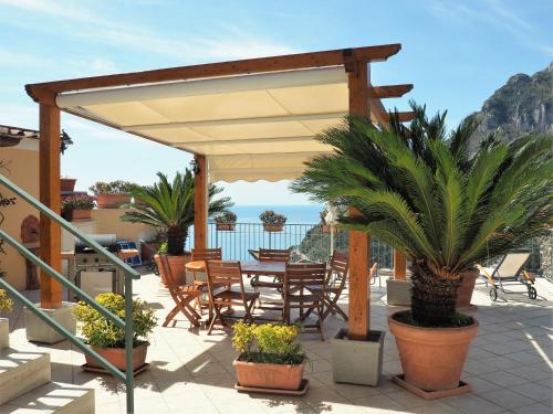 a patio with a table and chairs under a canopy at Casa TerryB - il Monticello in Positano