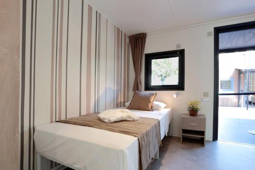 a bedroom with a bed and a window at Fabulous village in Casal Palocco