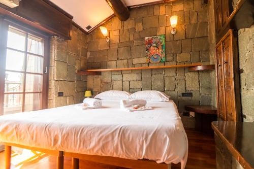 a bedroom with a large bed in a stone wall at Zavaglia House in Lainate