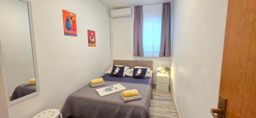 a small room with a bed and a mirror at Guest House Jasna in Novalja