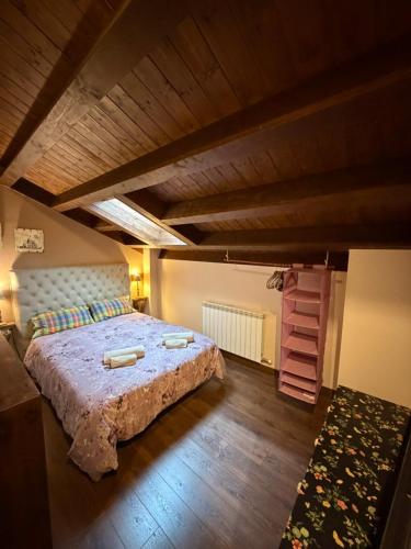 a bedroom with a large bed with a wooden ceiling at Casa Robelca in Biescas