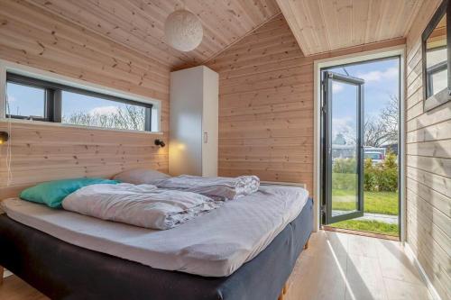 a large bed in a room with a large window at S749-Stroby-Nattergalevej-9 in Strøby