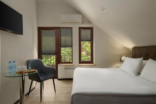a bedroom with a bed and a table and a chair at Elysium Gallery Hotel in Yerevan