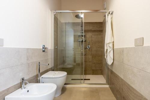 a bathroom with a shower and a toilet and a sink at Villa Lumiere in Modica