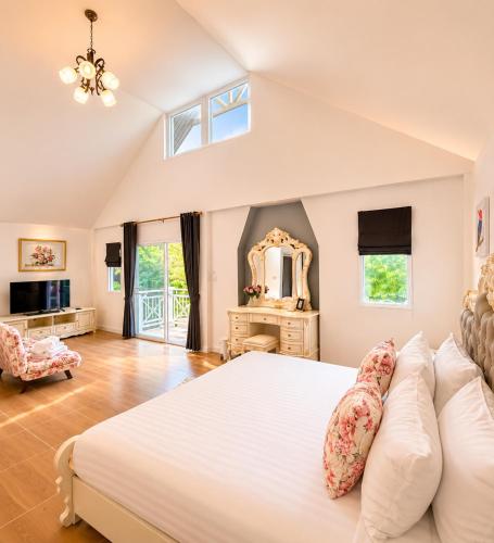 a bedroom with a large bed and a mirror at Kenikar Raintree Resort Chumphon in Chumphon