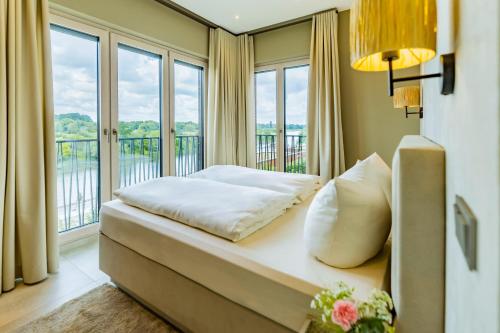 a bedroom with a bed and a balcony with windows at Elbblick Premium-Apartment zentral in Dresden in Dresden