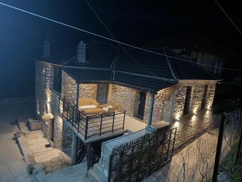 a brick house with a balcony at night at Vasiliki Pramanta villas in Pramanta