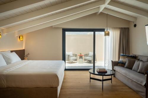 a hotel room with a bed and a couch at Aetheria Boutique Hotel & Spa in Markopoulo